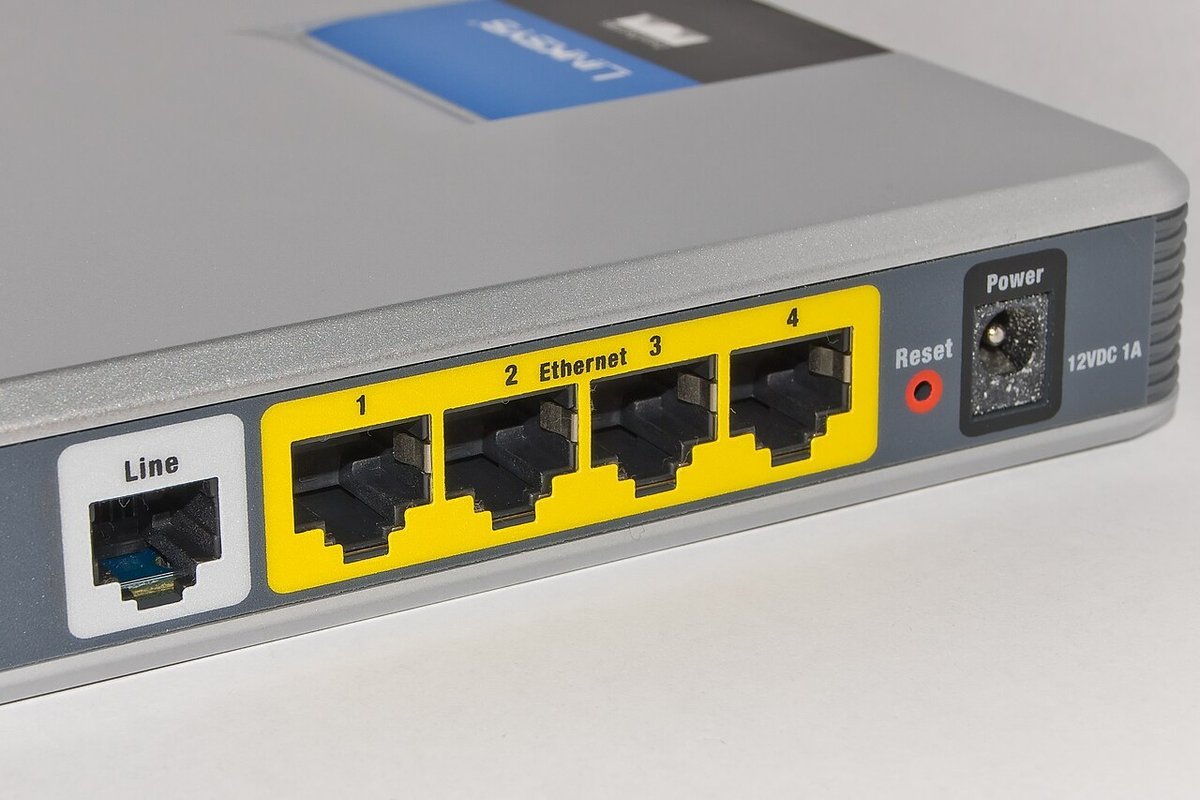 Bir ADSL modem yönlendiricinin arkasında hat girişi, dört sarı Ethernet portu ve güç girişi